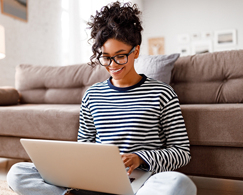 Woman in striped shirt working on a laptop
