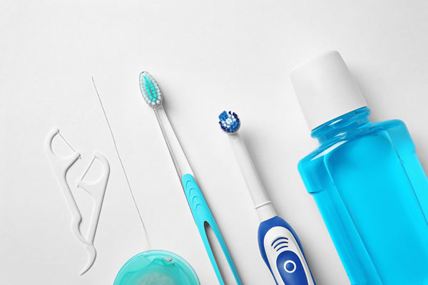 Dental hygiene tools including toothbrushes, dental floss, and mouthwash, emphasizing preparation for optimal oral health before a dental cleaning.