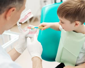 dentist showing a kid how to brush their teeth