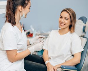 Dental professional engaging with a patient in a modern dental office, emphasizing personalized care and comfort for sensitive teeth treatment.