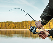 Person fishing with a rod in a serene outdoor setting, reflecting Dr. Frank's passion for fishing mentioned in his personal interests.