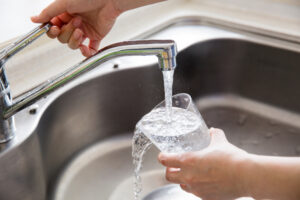 pouring a glass of water at a kitchen sink